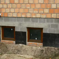 Wzmocnienie fundamentów w starym domu koszt. Dwa okna piwniczne, izolacja przeciwwilgociowa, nowe mury.