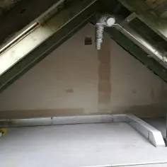Instalacja wentylacyjna przez ścianę budynku na poddaszu. Metalowe kanały i izolacja Climaflex.