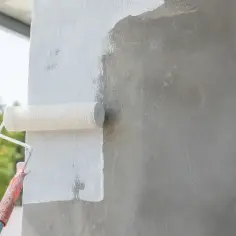 Malowanie posadzki betonowej wałkiem na biało. Prace wykończeniowe na zewnątrz.