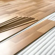 Układanie paneli na 1/3 podłogi. Nowe deski laminowane czekają na montaż.