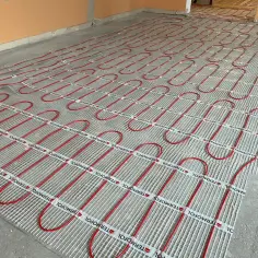 Siatka z rurkami do ogrzewania podłogowego. Wylewka na ogrzewanie podłogowe będzie wylewana na tę instalację.