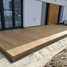Nowy taras na słupach betonowych, wykonany z desek kompozytowych, stanowi idealne miejsce do wypoczynku.