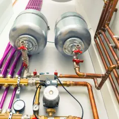 Instalacja CO z dwoma zasobnikami, pompą i manometrami. Dopuszczalny spadek ciśnienia w instalacji co jest kluczowy dla jej efektywności.