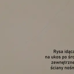 Pionowe pęknięcia ścian nośnych, widoczne jako delikatna linia biegnąca po skosie, sygnalizują potencjalne problemy konstrukcyjne.